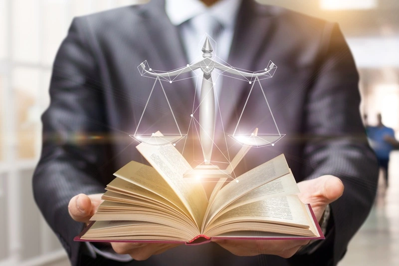 Lawyer holding a book and balance of equities